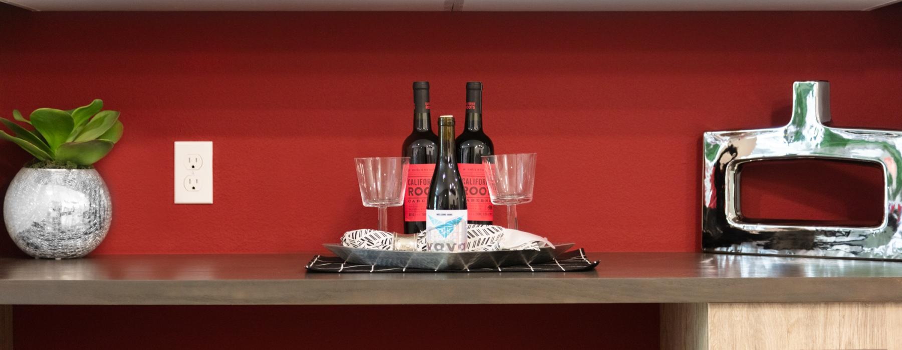 a counter with wine glasses and bottles on it